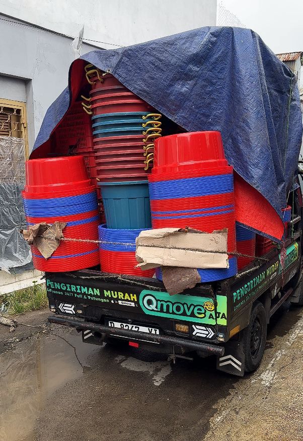 Ember dan tempat sampah ditutup terpal biru sebelum dikirim